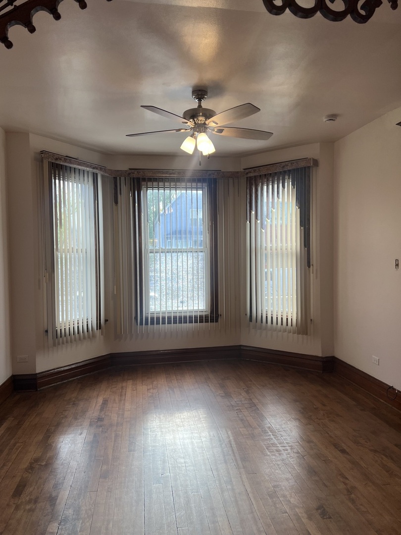 1921 North Pulaski Road, Unit 1 Chicago, IL 60639 - Photo 2 of 16 a view of an empty room with wooden floor and a window