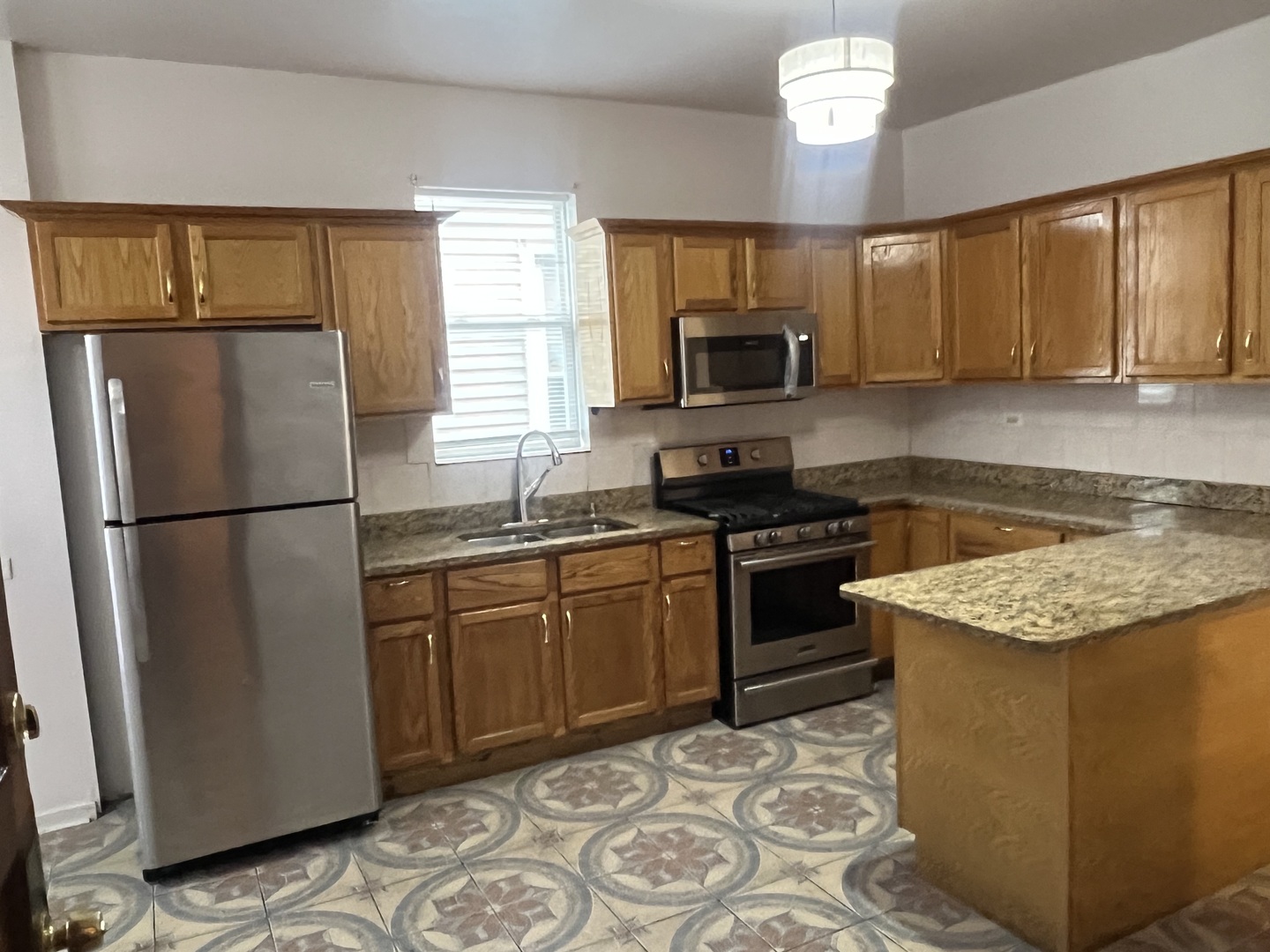 1921 North Pulaski Road, Unit 1 Chicago, IL 60639 - Photo 5 of 16 a kitchen with stainless steel appliances granite countertop a refrigerator stove microwave and sink