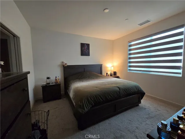 a bedroom with a bed and a tv on the dresser