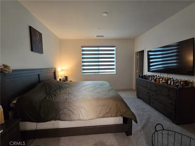 a bed sitting in a bedroom next to a window with dresser