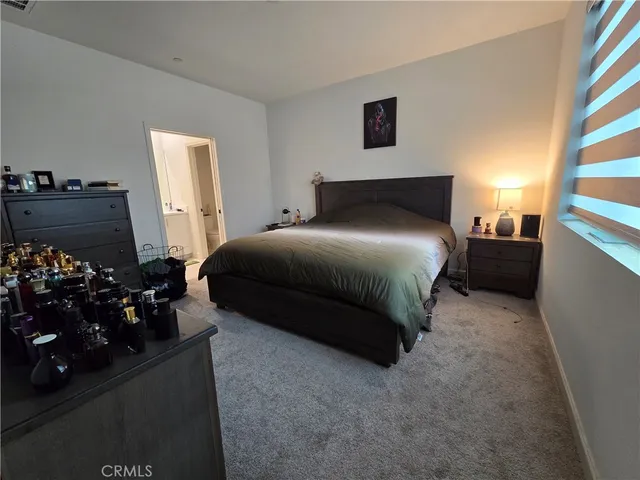 a bedroom with a bed and a potted plant