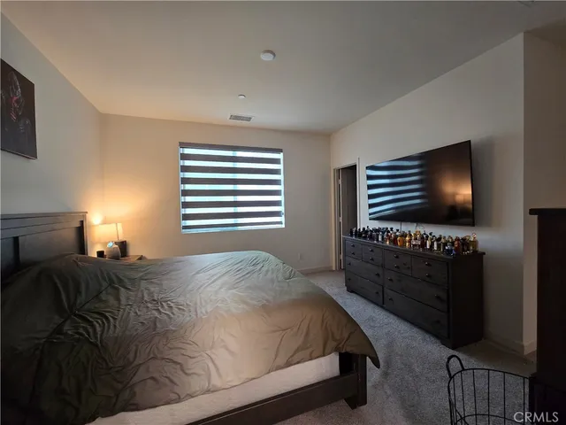 a bedroom with a bed next to a window