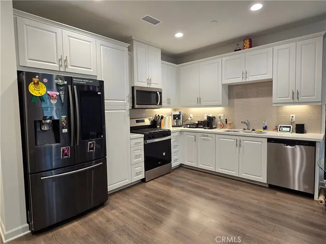 a kitchen with stainless steel appliances white cabinets and a refrigerator