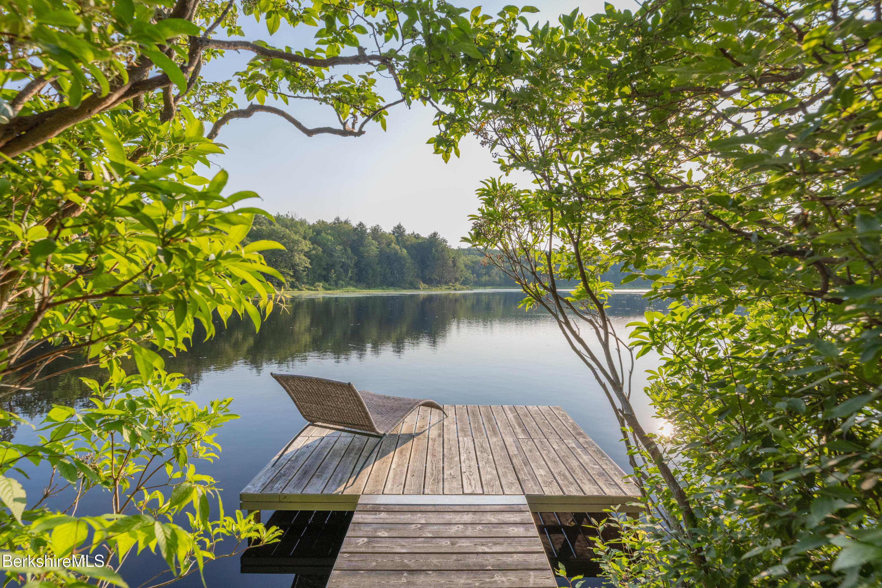 14 Sullivan Road Sandisfield, MA 01255 - Photo 18 of 54 a view of a lake with a floor to ceiling window next to a yard