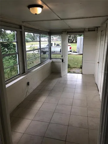 a large white kitchen with granite countertop a rug and a large window