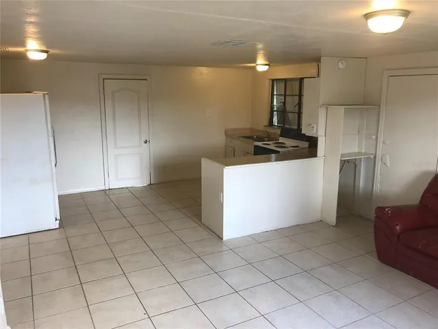 a kitchen with kitchen island granite countertop a refrigerator and a stove top oven