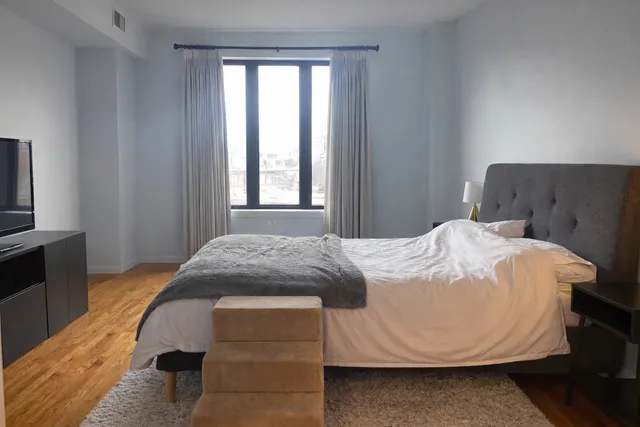 a bedroom with a bed and wooden floor