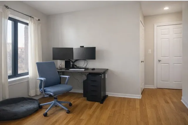 a view of a workspace with furniture and a window