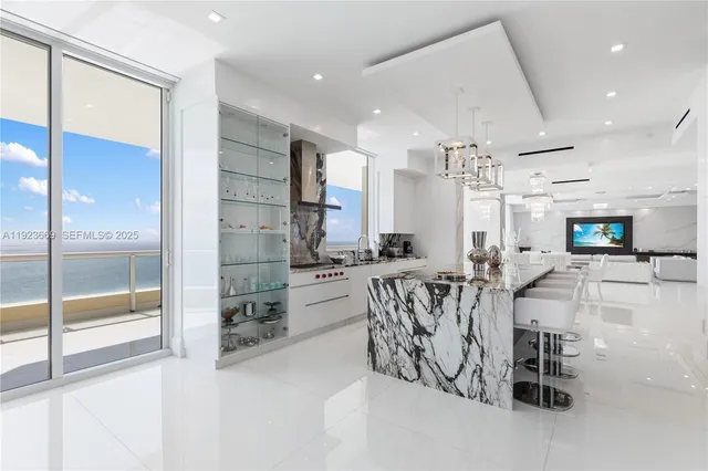 a view of kitchen with stainless steel appliances kitchen island granite countertop a sink a stove a dining table and chairs