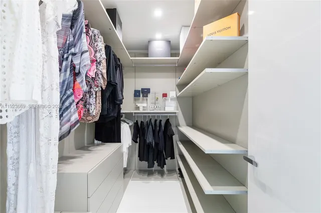 a spacious bedroom with a large bed and a chandelier