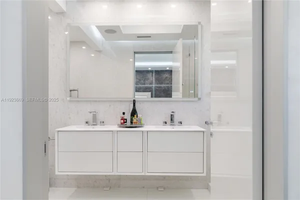 a bathroom with double vanity and a mirror