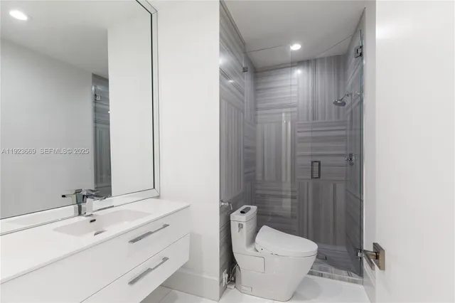 a bathroom with a sink a toilet and shower