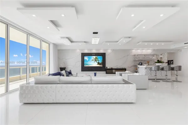 a view of a dining room with furniture a chandelier and kitchen view