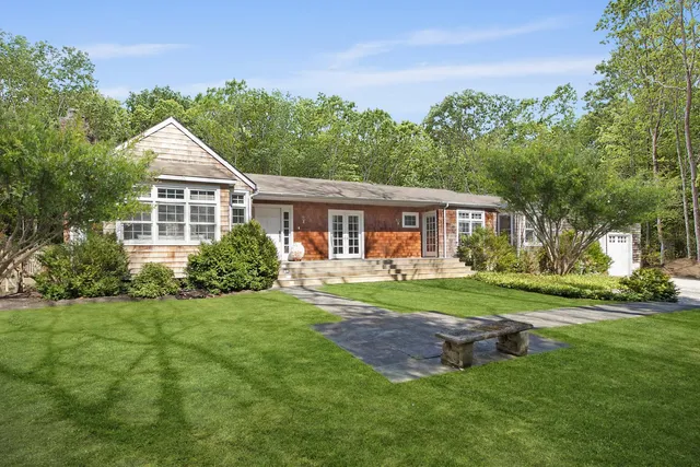 a front view of a house with a yard and trees