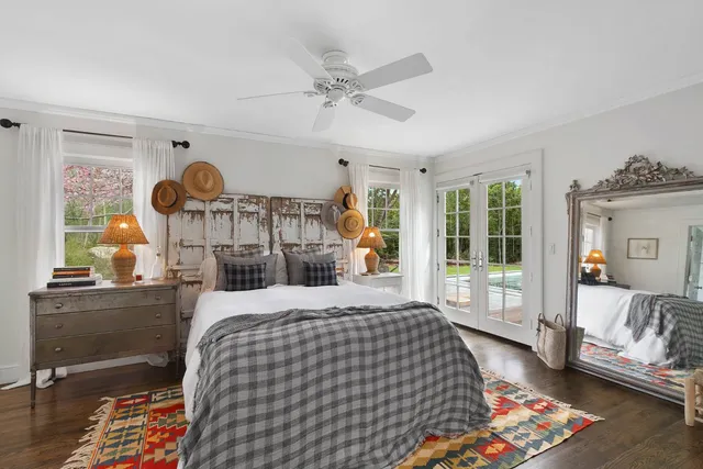 a bedroom with a bed mirror and a window