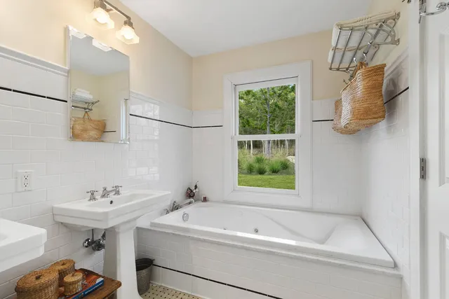 a bathroom with a sink vanity tub and a mirror