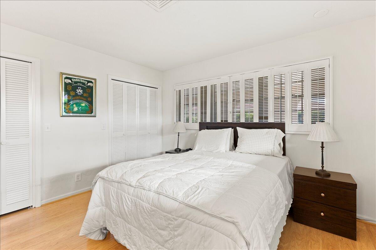 233 Rio Vista Circle Atlantis, FL 33462 - Photo 23 of 38 a bedroom with a bed and wooden floor