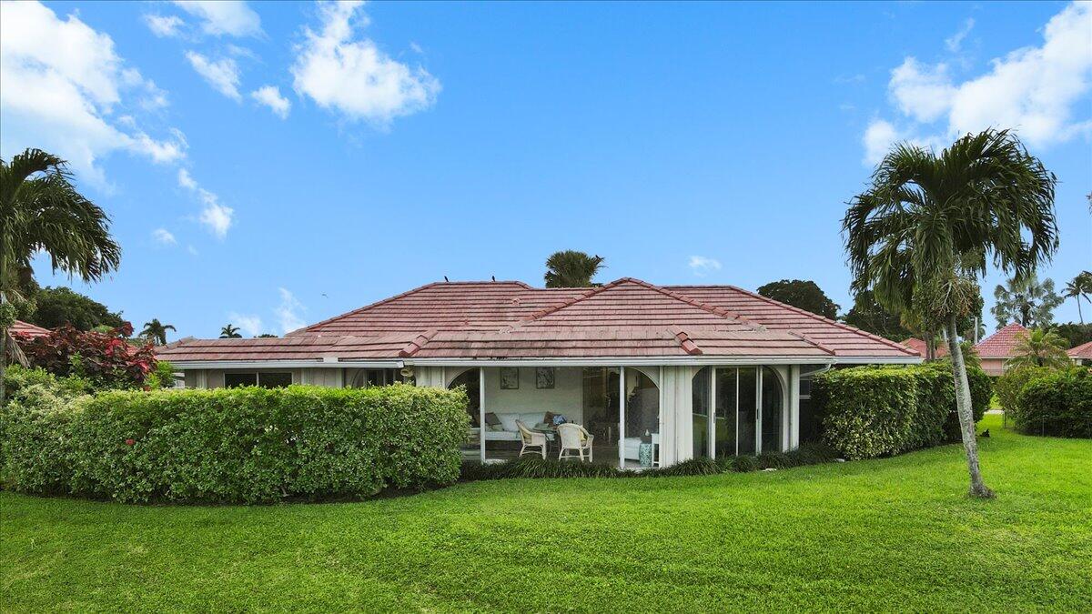 233 Rio Vista Circle Atlantis, FL 33462 - Photo 3 of 38 a view of a white house with a big yard and potted plants
