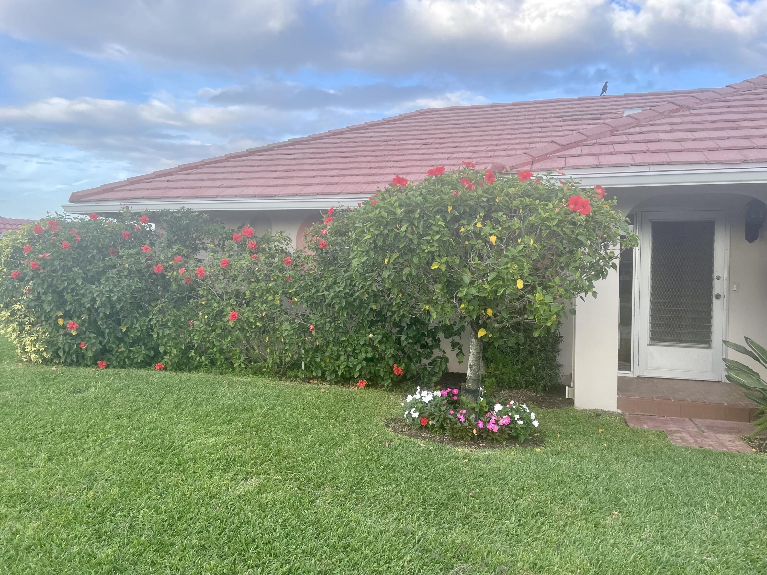 233 Rio Vista Circle Atlantis, FL 33462 - Photo 6 of 38 a view of a house with a yard and potted plants