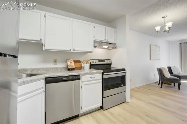 a kitchen with granite countertop white cabinets and white appliances