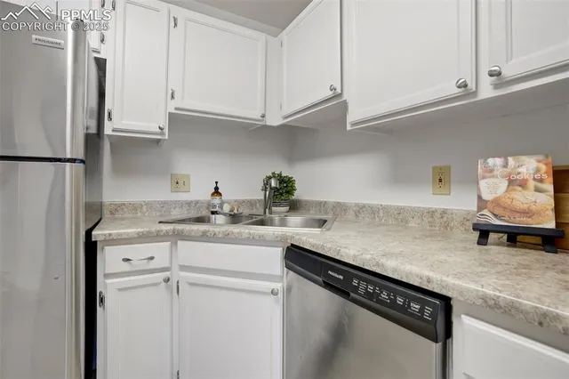 a kitchen with stainless steel appliances granite countertop a sink and a white cabinets