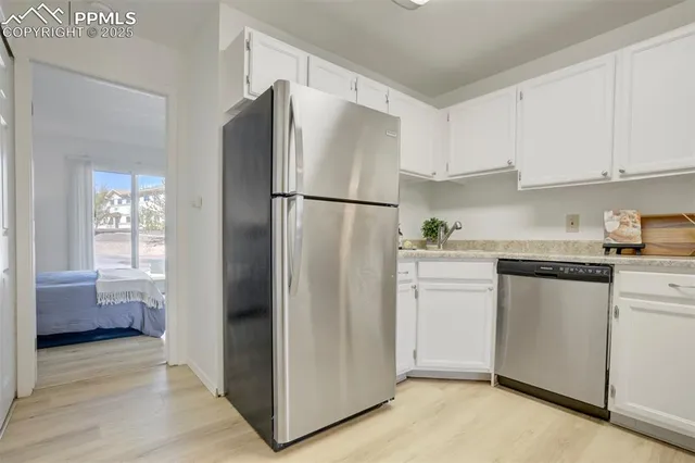 a kitchen with white cabinets and refrigerator