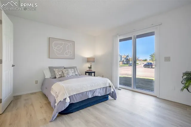 a bedroom with a balcony a bed and a painting on the wall