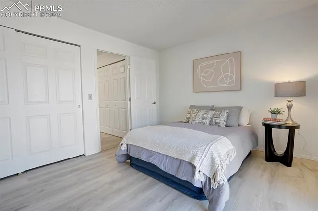 a bedroom with a bed and painting on the wall