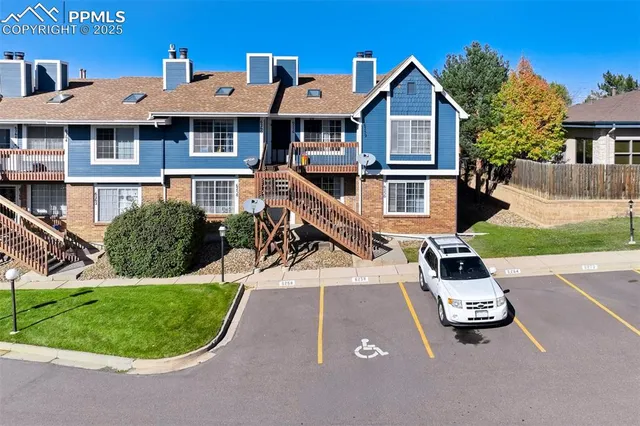 a view of a white house with a yard patio and a garden
