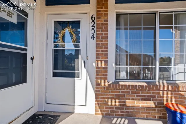 a view of a brick house with glass windows