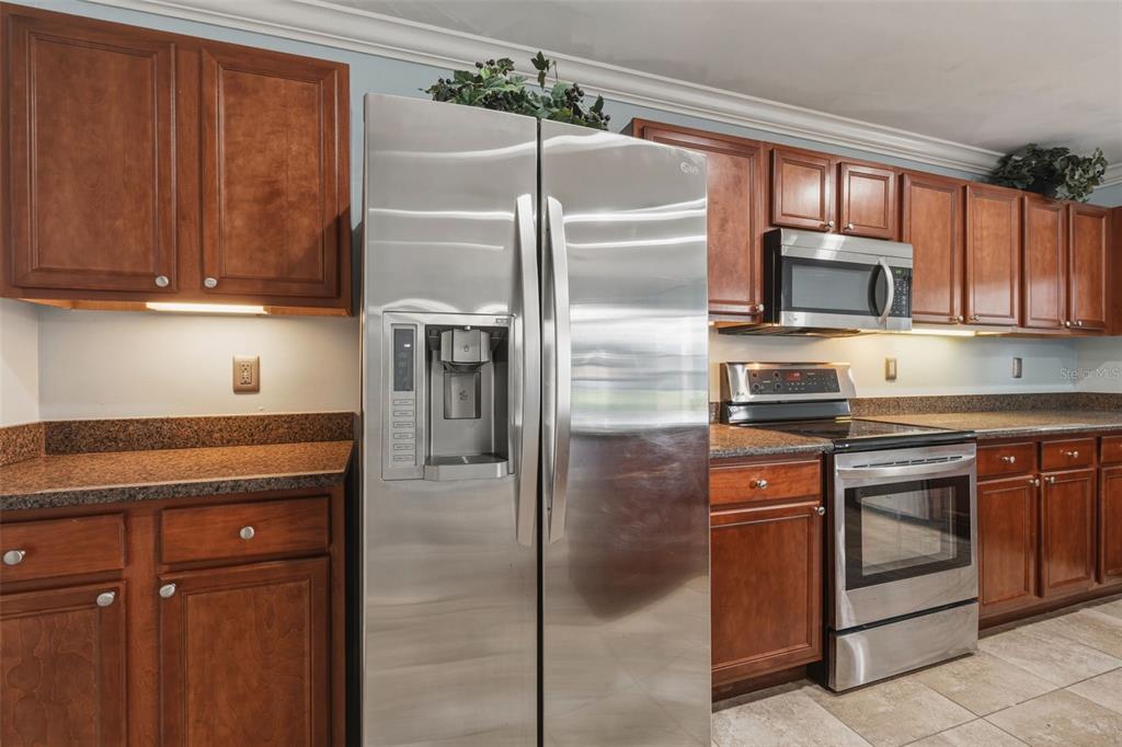 25134 Palisade Road Punta Gorda, FL 33983 - Photo 29 of 58 a kitchen with granite countertop a refrigerator stove and microwave