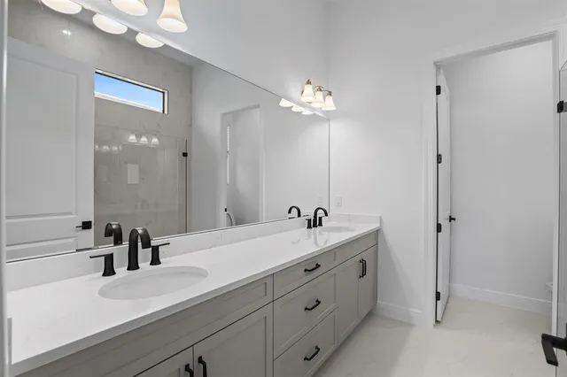a bathroom with a double vanity sink a mirror and a shower