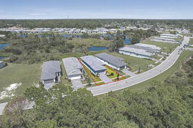 an aerial view of a house with a garden and lake view