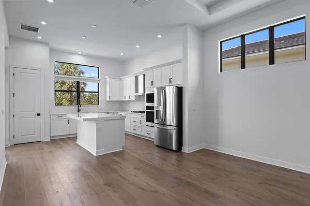 a kitchen with a refrigerator and white cabinets