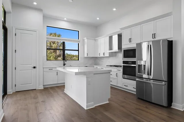 a kitchen with white cabinets and stainless steel appliances
