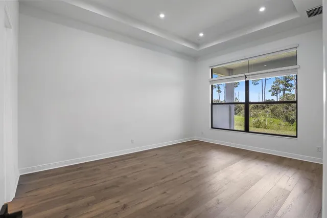 an empty room with wooden floor and window