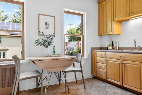 a kitchen with stainless steel appliances a table and chairs in it