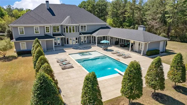 a view of a house with pool and chairs