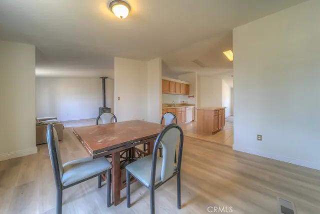 a view of a livingroom with wooden floor and a kitchen space