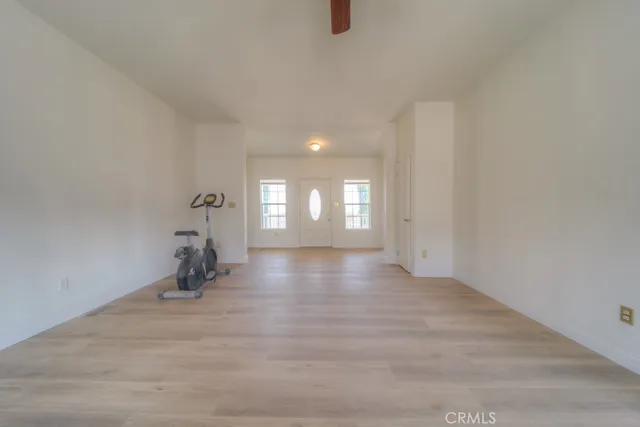 a view of empty room with wooden floor and fireplace