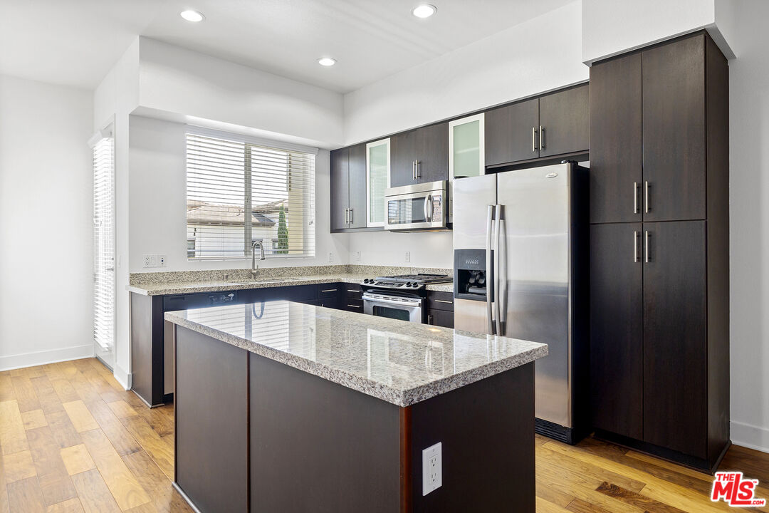 12920 West Runway Road, Unit 222 Playa Vista, CA 90094 - Photo 3 of 23 a kitchen with granite countertop a refrigerator and a sink