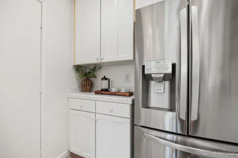a kitchen with stainless steel appliances granite countertop white cabinets and a refrigerator