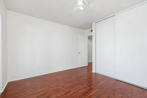 a view of an empty room with wooden floor