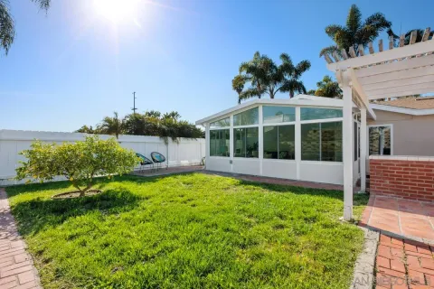 a view of a house with a yard and potted plants