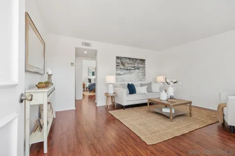 a living room with furniture and a wooden floor