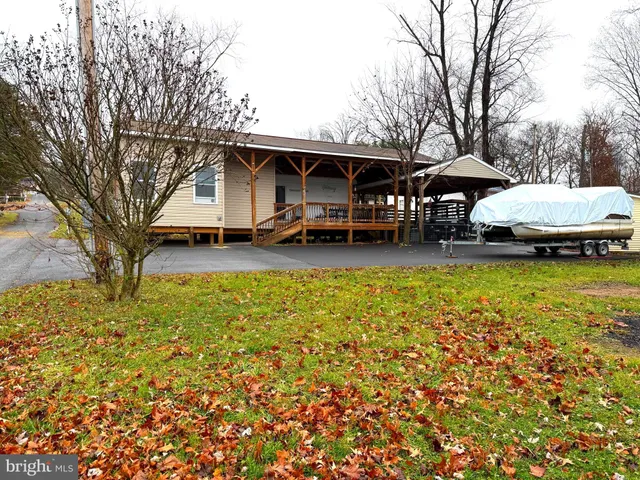 a view of a house with a big yard and large trees