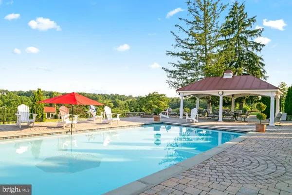 a view of a swimming pool with a table and chairs under an umbrella