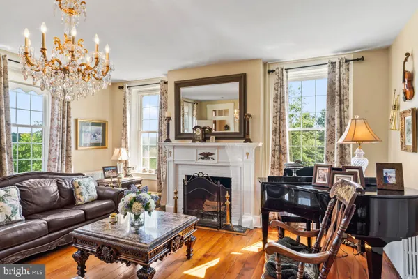 a living room with furniture a chandelier and a fireplace