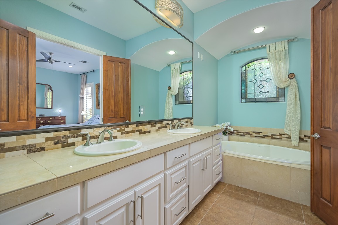22 Borello Drive Austin, TX 78738 - Photo 18 of 26 a bathroom with a granite countertop sink mirror and bathtub