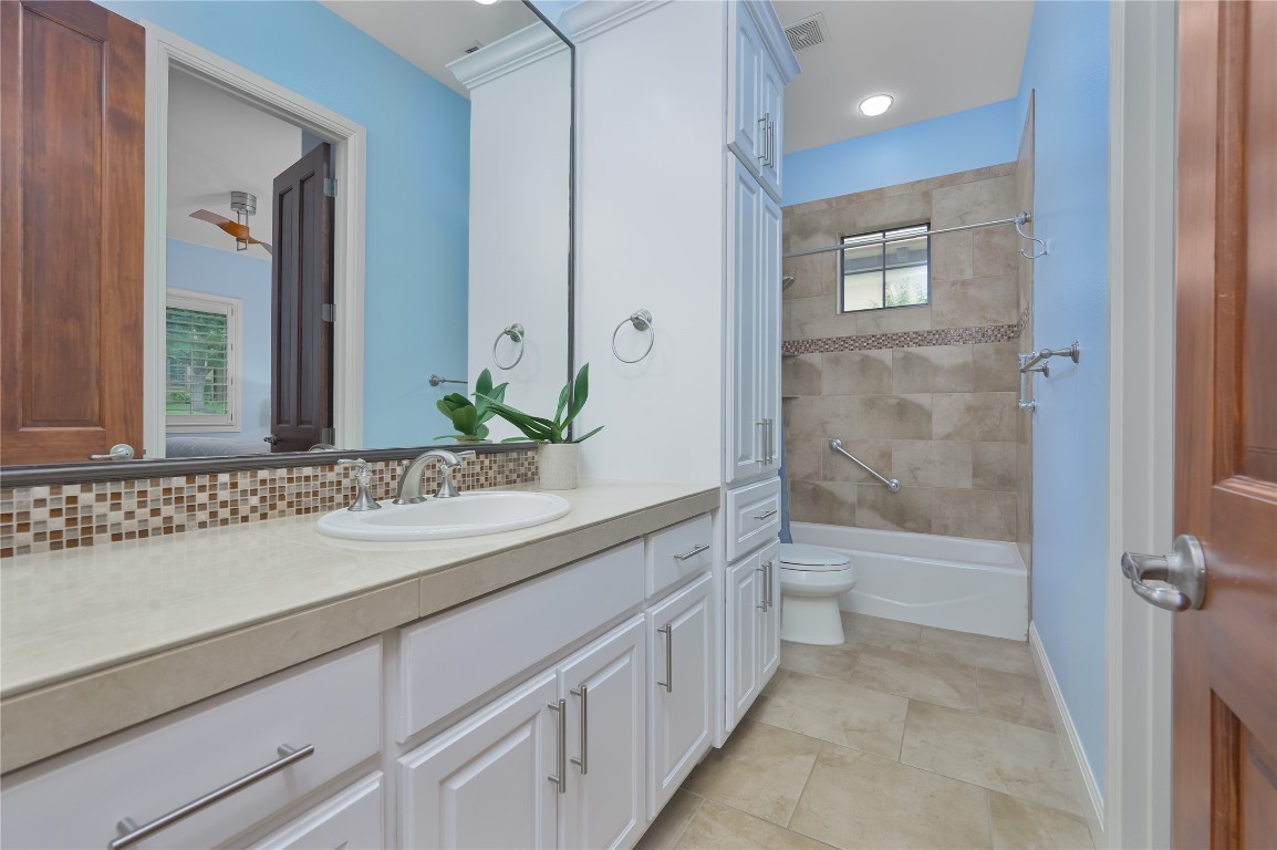22 Borello Drive Austin, TX 78738 - Photo 21 of 26 a bathroom with a granite countertop sink a toilet and shower